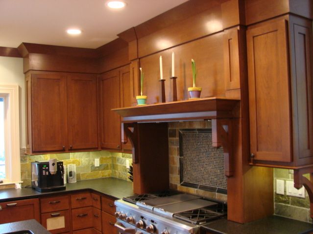 Stained cherry kitchen with custom mantel-style range hood built by Division Seven Millwork
