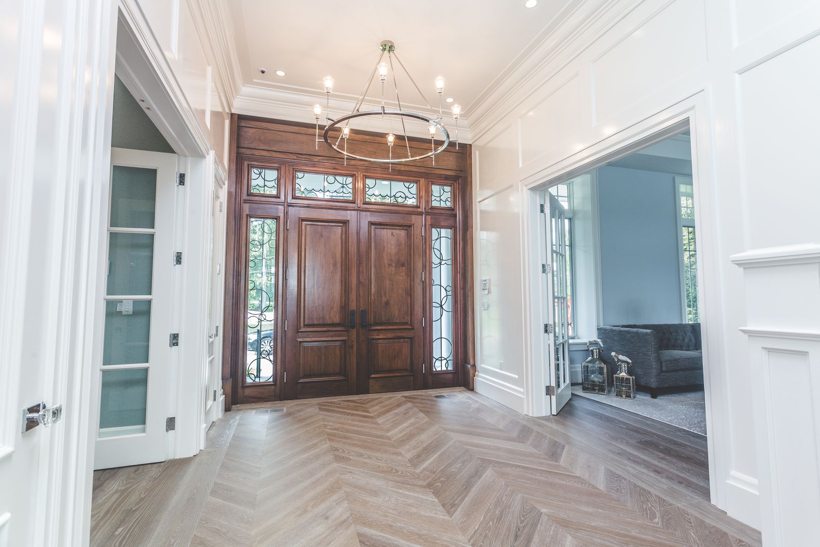 Entry foyer with wood double door and wainscoting millwork by Division Seven Millwork