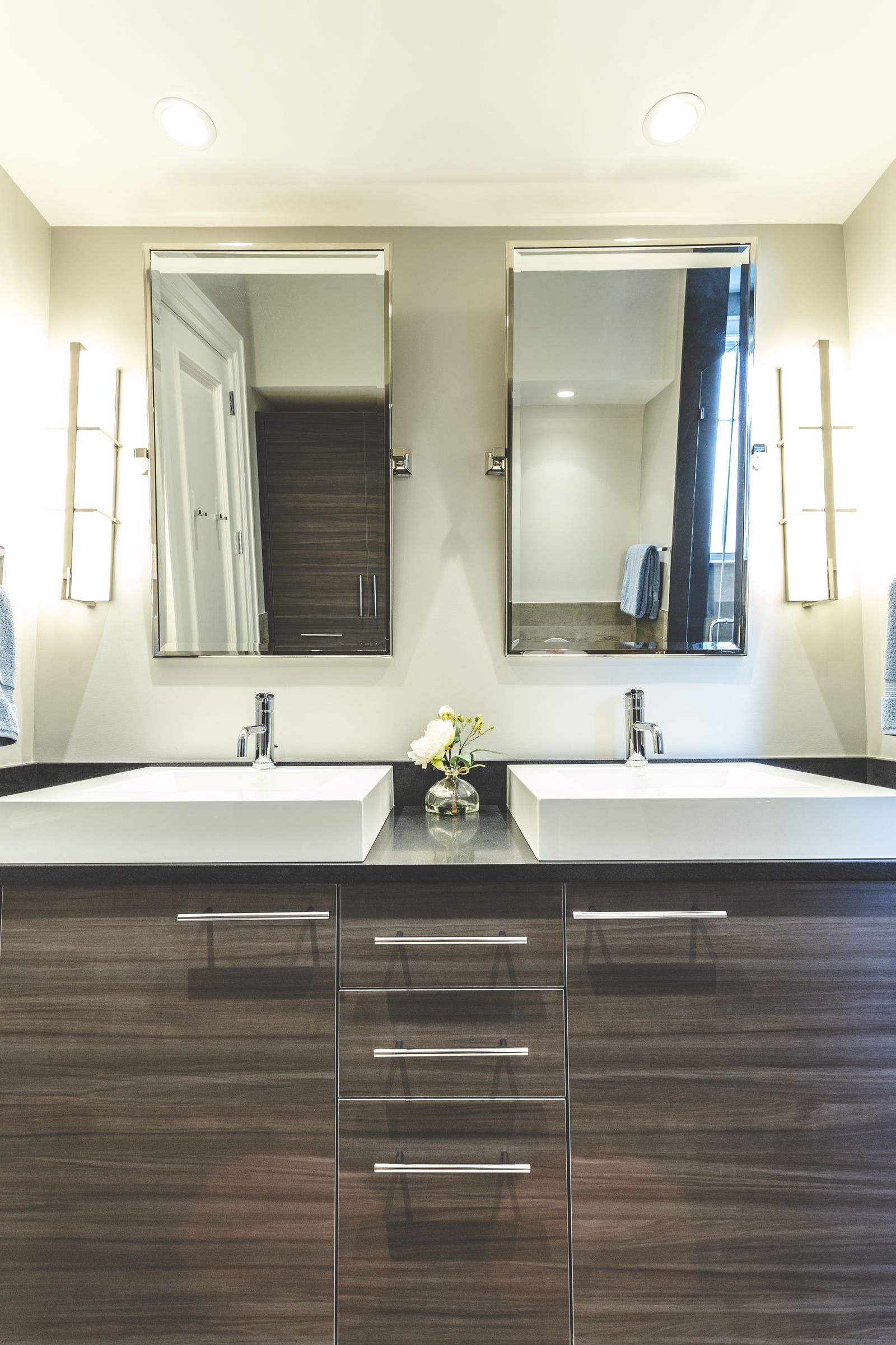 Dark wood modern double vanity with vessel sinks, built by Division Seven Millwork